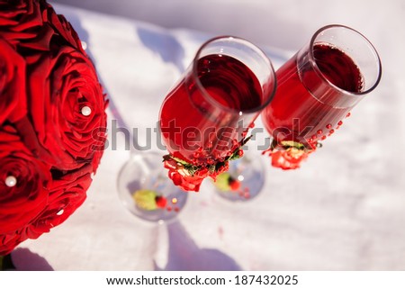 Red wedding bouquet with a glass of red wine