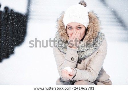 Portrait of a beautiful girl who warms the frozen hand nose winter