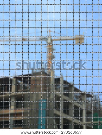 Danger building site sign in construction site. Concept photo of Building,construction work, health and safety, focus fence mesh background.