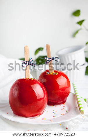 Apples in a red candy on sticks, candy apple on a wooden background