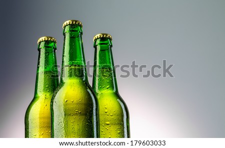 Closeup of three green beer bottles neck