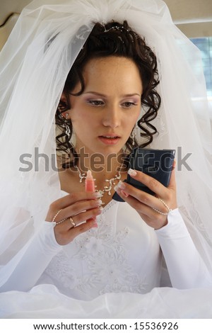 The bride in a limousine does a make-up