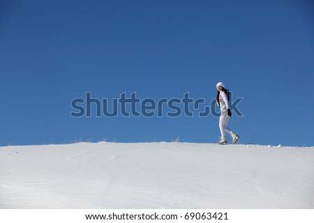 The running girl on snow road to mountains