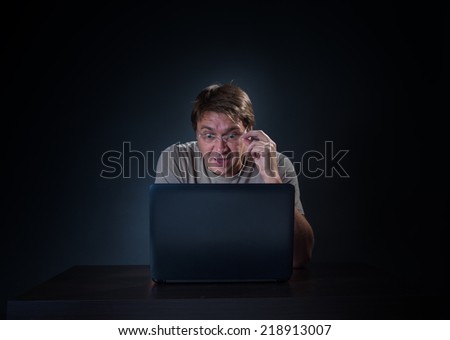 the man behind the laptop on dark background