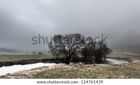 A river through Norwegian landscape in foggy weather