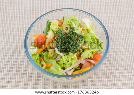 Bowl of healthy green garden salad with fresh vegetables from above