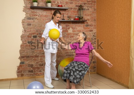 Senior Woman Sitting On A Chair And Holding Spiky Ball During Physiotherapy