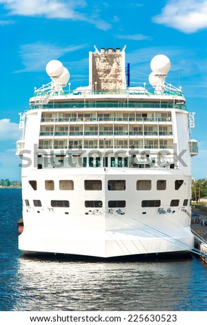 Huge white passenger cruise ship in port on a blue sky background. Outdoors
