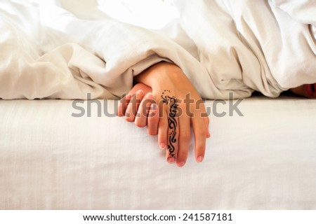 Sleeping little child hands on white bed linen. Indoors closeup.