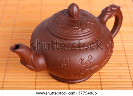 Classic chinese teapot of brown clay on bamboo rug