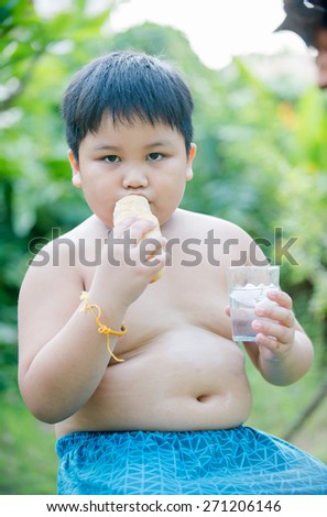 cute fat boy with bread on nature background