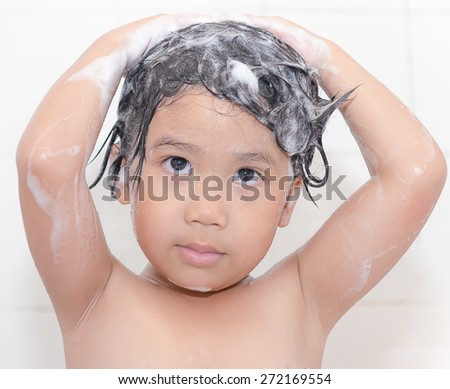Cute asian girl is washing her hair in bath. The symbol of purity and hygiene education