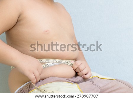 Fat boy measuring his belly with measurement tape