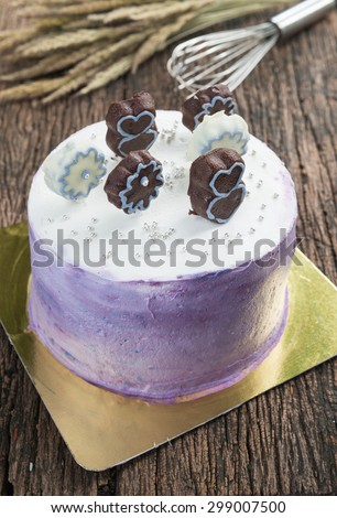 BIg fancy cake and chocolate on top on wood background