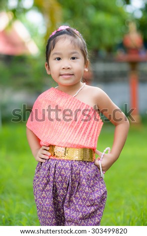 Cute asian girl wearing typical thai dress on nature background