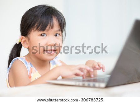 education, school, technology and internet concept - Cute girl with laptop pc at home