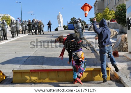 ATHENS, GREECE -DEC. 09: Two young protesters throw a traffic cone towards riot police outside Greek Parliament, in Athens, December 09, 2008.