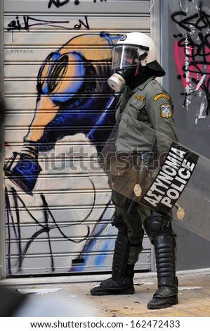 Athens, Greece - December 07. Riot Police Officer Wearing A Gas Mask In Front Of Graffiti Of A Gas Mask, During Clashes In Athens, December 07, 2008.