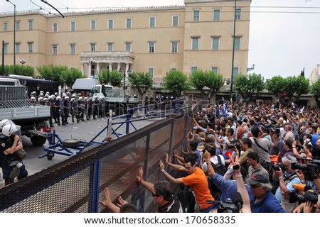 ATHENS, GREECE -JUNE 15. Angry crowd pushing police erected fence outside the Greek Parliament during demonstration, in Athens, June 15, 2011.