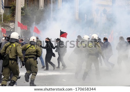 ATHENS, GREECE-FEB.23.  Protesters holding flags being chased by riot police during demonstration in Athens, February 23, 2011.
