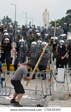ATHENS, GREECE -JUNE 15. Man threatening riot police with stick at the Greek Parliament during demonstration , in Athens, June 15, 2011.