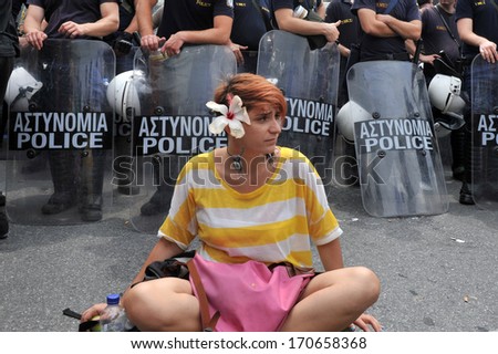 ATHENS-GREECE,JUNE 15. A young girl is protesting peacefully in front of a riot police during demonstration in Athens, June 15, 2011.