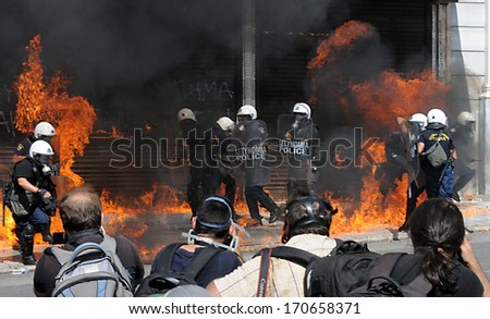 ATHENS, GREECE -SEPT. 26. Photojournalists taking shots of riot police in flames, from Molotov bombs during demonstration in Athens. September 26, 2012.