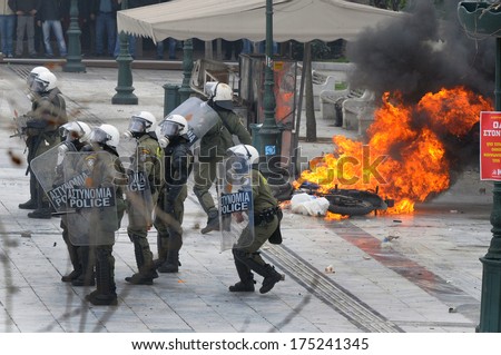 ATHENS, GREECE-FEB.23 Riot police next to motorbike on fire, during demonstration in Syntagma square in Athens  February 23, 2011.