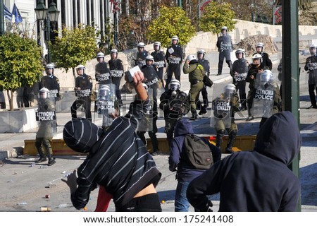 ATHENS, GREECE-DEC.10.  Protesters throwing stone to police during demonstration in Athens, December 10, 2011.