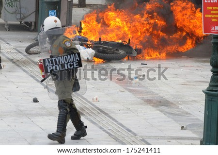 ATHENS, GREECE-FEB.23 Riot police looking at motorbike on fire, during demonstration in Syntagma square in Athens  February 23, 2011.