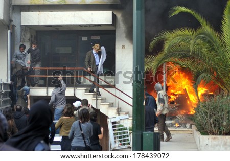 ATHENS - GREECE DEC. 08. A bank office is in fire after an arson attack, during mass riots and the residents of the building are trying to escape, in Athens, December 07, 2008.