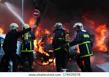 ATHENS-GREECE - April 26. Fire fighters tries to extinguish burning cars following an arson attack by anarchists at a central police station in Athens, April 26, 2007.