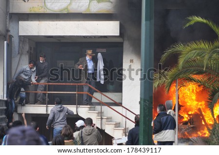 ATHENS - GREECE DEC. 08. A bank office is in fire after an arson attack, during mass riots and the residents of the building are trying to escape, in Athens, December 07, 2008.