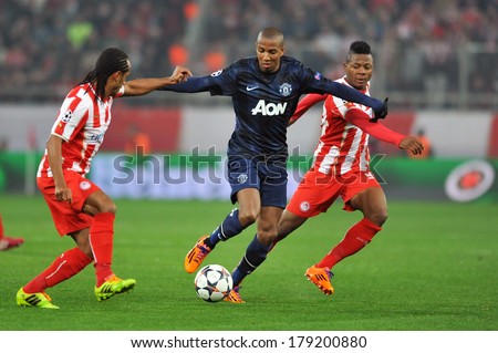 PIRAEUS, GREECE -FEB. 25. Olympiakos vs Manchester United 2-0. Manchester United's Ashley Young (center) battle for the ball  with Olympiakos' Michael Olaitan (right) in Peiraeus, February 25, 2014