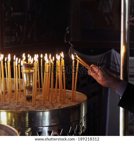 ATHENS, GREECE, APRIL 18 2014: Pilgrims, light candles during the ceremony of Good Friday before Easter, in the monastery of Penteli, north Athens.