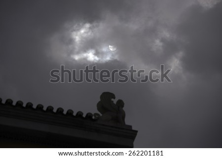 Athens Greece, March 20, 2015.The partial solar eclipse as seen in partly cloudy sky above the roof of the University of Athens, local time 11:59.