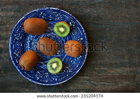 Kiwi on the blue vintage plate on the dark wooden table