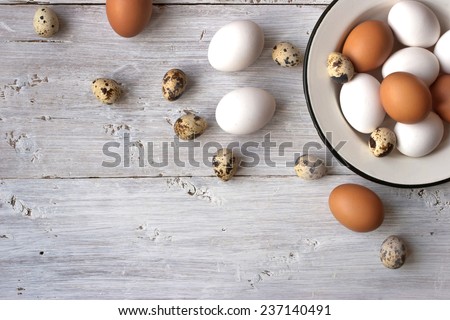 Chicken and quail eggs on the white wooden table horizontal