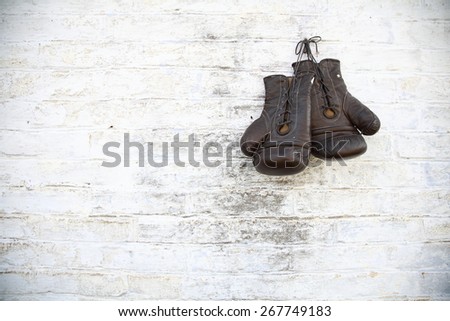 old gloves hanging on a brick wall