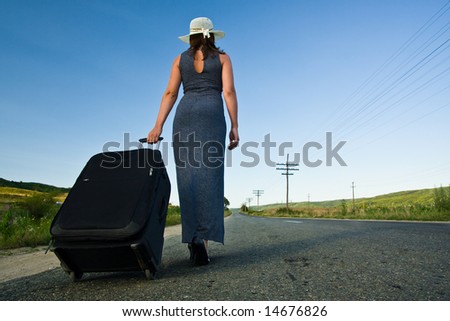 Woman carrying a heavy bag on the road