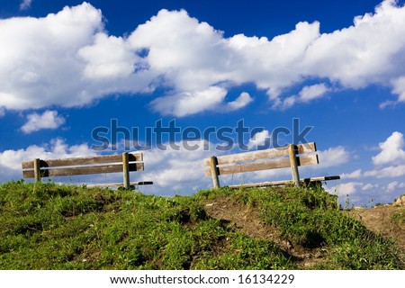 Two benches on top of a hill
