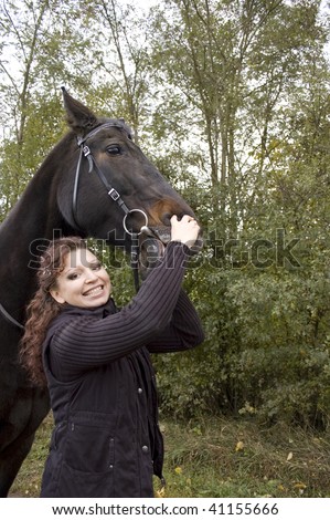Woman tries to show the horse\'s teeth.