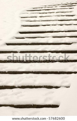 Stairs in a park is covered with snow.