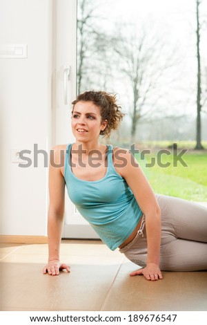 Doing exercises in front of the window of her house
