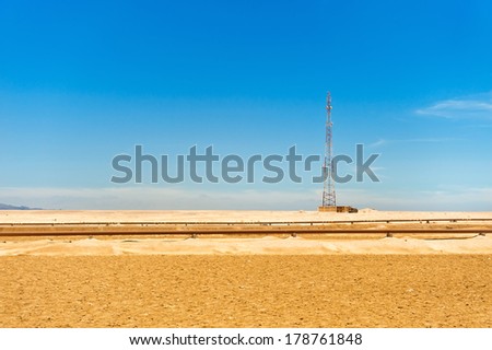 Telecommunications tower and oil pipeline in the Sahara desert, Egypt.