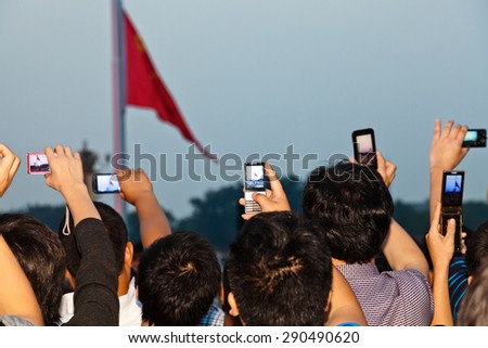 BEIJING, CHINA - SEPTEMBER 9: Crowd shooting for Flag Landing Ceremony on September 9, 2012, Beijing, China. Honor guards hold a flag-raising flag-landing ceremony at dawn or dusk every day.