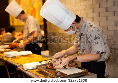 BEIJING, CHINA - SEPTEMBER 1, 2012: Chef are cutting roasted duck in a restaurant in Beijing,China on September 1, 2012.