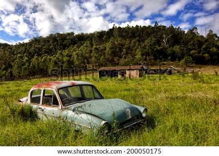 WOLLOMBI,AUSTRALIA - JUNE 10,2012: A vintage car sits abandoned in a field. Wollombi is a picturesque village 130km north of Sydney, in the wine-producing Hunter Valley region.