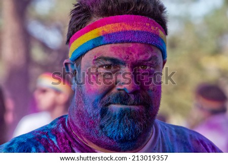 SYDNEY,AUSTRALIA - AUGUST 24,2014: A competitor in the \'Color Run\' fun run in Centennial Park. Runners are doused in coloured powder, bubbles and water as they run the 5K course.