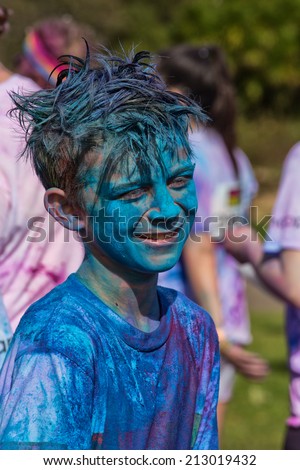SYDNEY,AUSTRALIA - AUGUST 24,2014: A competitor in the \'Color Run\' fun run in Centennial Park. Runners are doused in coloured powder, bubbles and water as they run the 5K course.